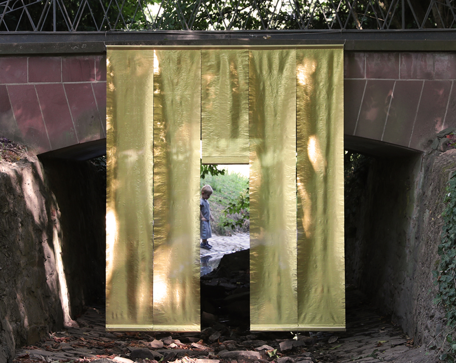 Tempio dell’acqua II  – <br>
Installation im Biebricher Schlosspark im Rahmen des Art Festivals „Poesie im Park“, Wiesbaden, am Bachverlauf des Mosbaches, Metallfasergewebe, Holz, Aluminium, 2022
